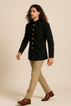 Side view of black Bandhgala Jodhpuri suit with gold-tone buttons and tan trousers for a Paris wedding reception
