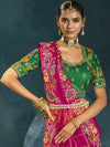 Close up of heavy hand embroidery and zari work on emerald green blouse and pink saree in California