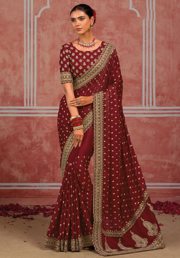 Maroon silk saree featuring detailed golden embroidery border and designer blouse