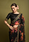 Model wearing black georgette floral saree with foil border – elegant side pose