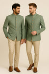 Two men in sage green Bandhgala Jodhpuri suits with beige trousers for a New Jersey wedding