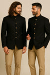 Two men in black Bandhgala Jodhpuri suits and tan trousers for a Frankfurt wedding guest look