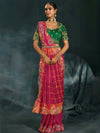 Front pose of model wearing a rani pink embroidered saree with heavy green blouse in Jaipur for Rajasthanis